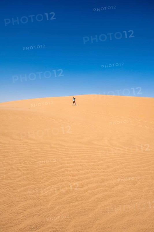 Lonely person photographing on a sand dune, sand dunes with wave patterns, sea of dunes, sandy desert, impressive desert landscape, Namib Naukluft Park, Namib Desert, Namibia