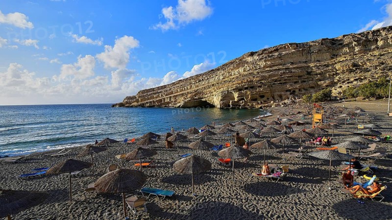 Neolithic caves, former hippie paradise, beach with umbrellas and sun beds by the sea, quiet surroundings with rocks, Matala, south coast, Crete, Greek islands, Greece