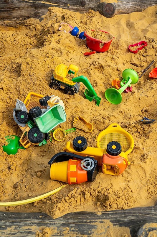 Sandpit, on a children's playground, sandpit with various plastic toys, excavator, shovels, moulds Sauerland, North Rhine-Westphalia, Germany