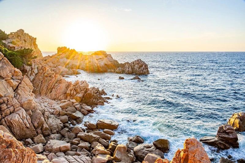 Landscape of the coastline with blue water at Costa Paradiso on a sunny day at sunset, Sardinia, Italy
