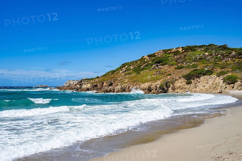 Coastline with emerald green and blue water on a sunny day at Rena Majori beach, Sardinia, Italy