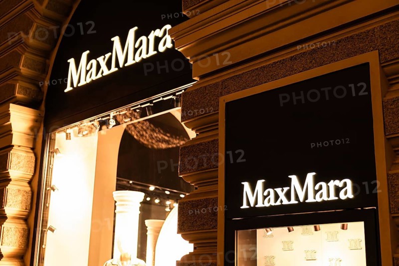 Vienna, Austria - 15 December, 2025: MaxMara store sign illuminated at night in Vienna, Austria. The architecture features classic European design with ornate details