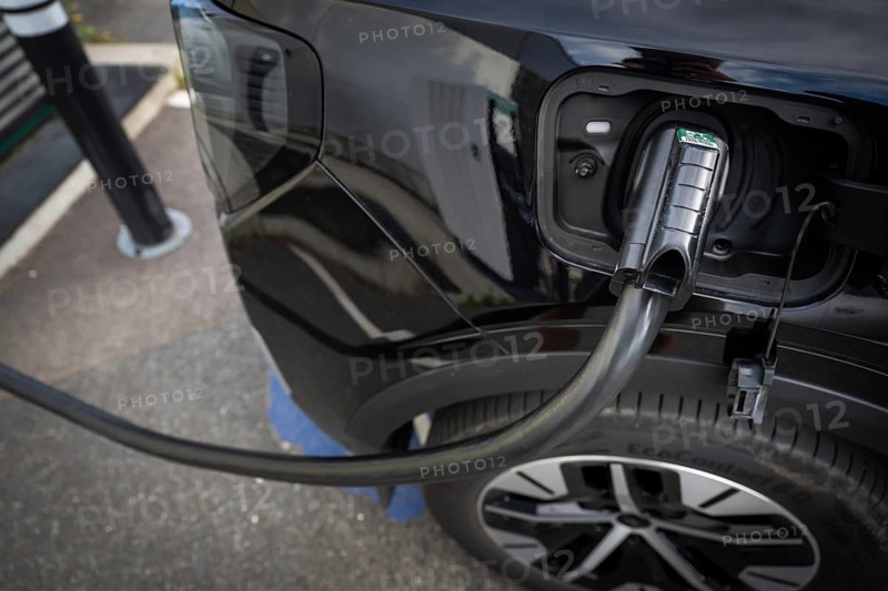 Fully electric Ford Explorer is being charged, charging cable in electric tank, charging station for electric vehicles, Norway