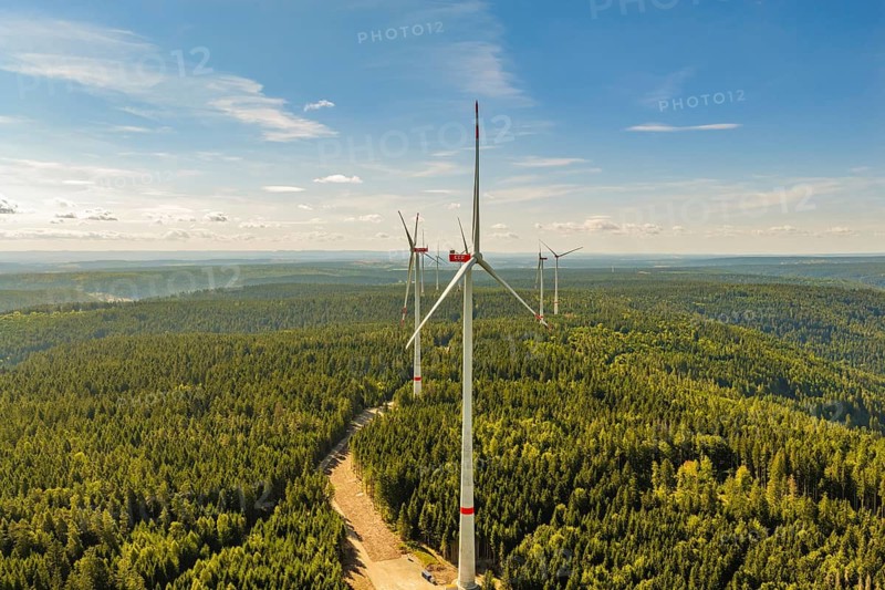Wind turbines rise above a wooded horizon under a partly cloudy sky, Besenfeld, Freudenstadt district, Germany