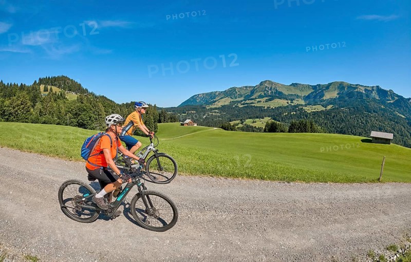 Two senior girl friends have fun during a ebike cycling tour in the Bregenz Forest near Sibratsgfäll, Vorarlberg, Austria