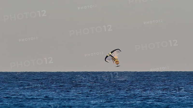 Wingfoiller, daring kitesurfer over the ocean waves, windsurfer, Meltemi windsurfing spot, Devils Bay, Paralia Vatha, Vatha Beach, south-east coast, Karpathos, Dodecanese, Greek Islands, Greece