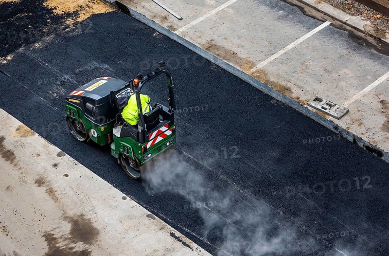 Tandem roller compacts an asphalt surface following road repair, Schöneberg, Berlin, Germany
