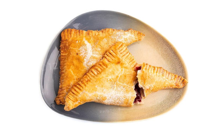 Triangles Pie, Puff Pastry, Samsa with cherry jam isolated on white background, top view, flat lay, close up