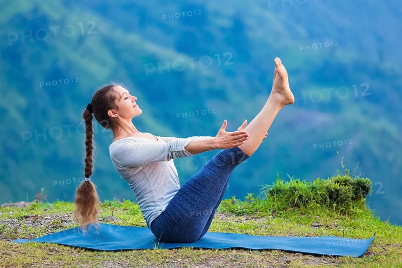 Yoga outdoors, young sporty fit woman doing Ashtanga Vinyasa Yoga asana Navasana, boat pose, in Himalayas