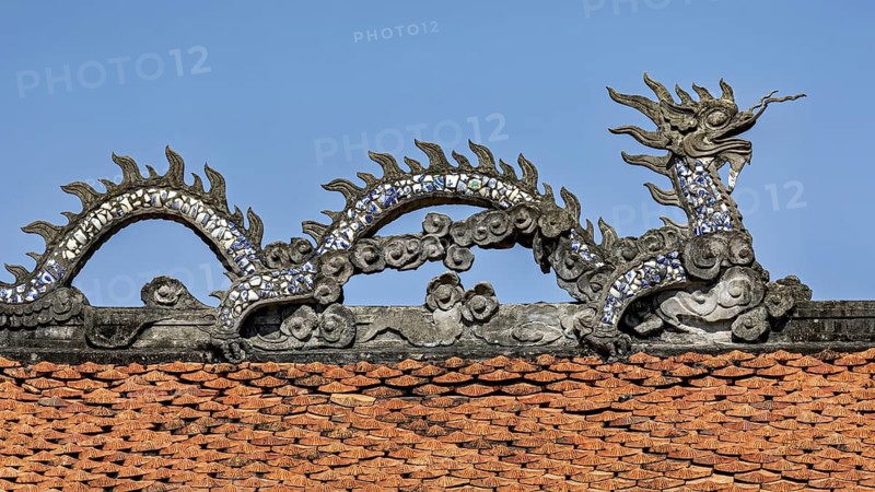 Traditional dragon figure on a roof, decorated with ceramic tiles, under a blue sky, dragon figure on the Temple of Literature in Hanoi Vietnam