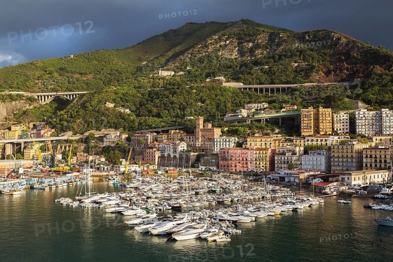 High angle view of marina with luxurious private yachts and sailboats bordered by apartment buildings in late summer, Port of Salerno, Campania region, Italy