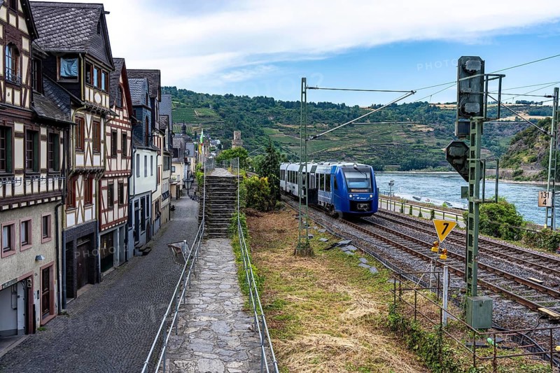 Local train, Regioexpress, in the Upper Middle Rhine Valley, runs directly in front of the residential buildings, close to the buildings, in Oberwesel, along the historic city wall, on the left bank of the Rhine between Rüdesheim and Koblenz, one of the busiest railway lines in Europe, around 230 trains, including over 130 freight trains, run on the train ticket around the clock, extreme noise pollution for residents, Some of whom live a few meters from the train line, Rhineland-Palatinate, Germany