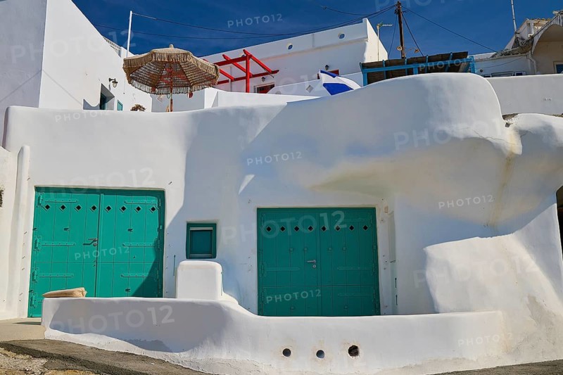 White, cubist building with green doors and shady parasol in a Mediterranean atmosphere, syrmata, boat garages, boathouse, boathouses, beach house, Goupa, Goypa, Goupa Kara, Kimolos, Cyclades, Greek Islands, Greece