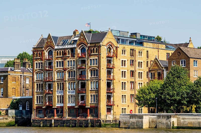 The Venetian Gothic facade of Oliver's Wharf, a converted Victorian tea warehouse now riverside apartments on the Thames at Wapping, London, England, United Kingdom