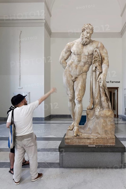 Museum visitors in front of Hercules Farnese, monumental marble statue by sculptor Gykon, Farnese Collection, Naples National Archaeological Museum, Naples, Campania region, Italy