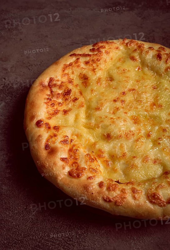 Khachapuri in Megrelian, a traditional Georgian dish, flatbread with cheese, top view, no people