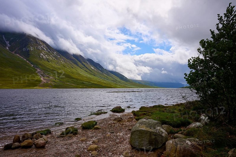 A lake with a rocky shore lies between cloudy mountains, Loch Etive, Argyll and Bute, Scotland, United Kingdom, Great Britain