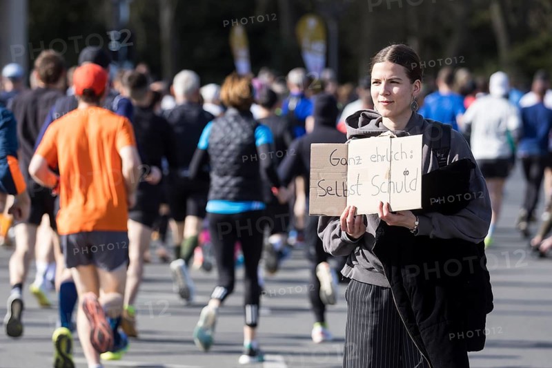 A person at the edge of the course holds a sign Honestly: it's your own fault at the 44th Generali Berlin Half Marathon 2025 in Berlin on 6 April 2025