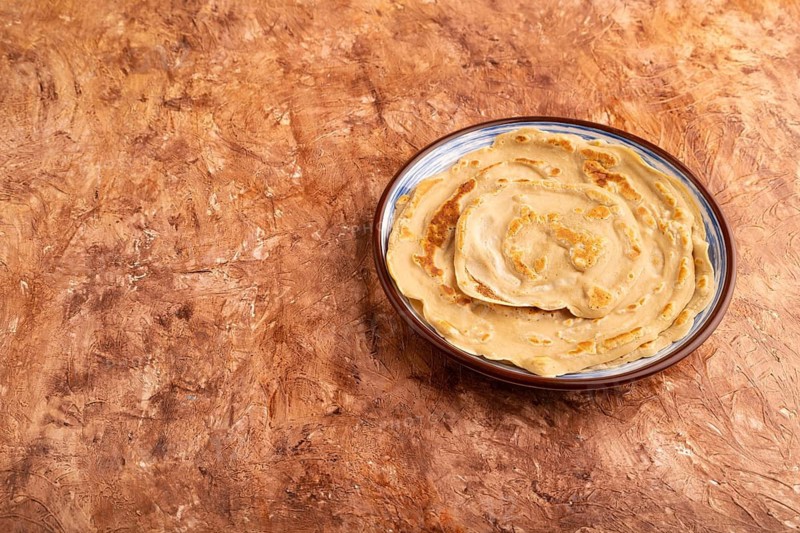 Stack of Plain Fried pancakes on brown concrete background. side view, copy space