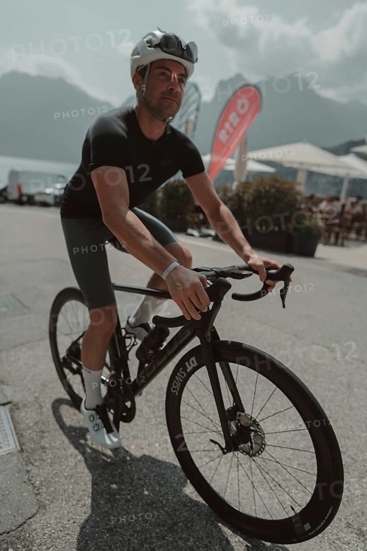 Young man riding a racing bike on Lake Garda. Sunny weather and dolce vita