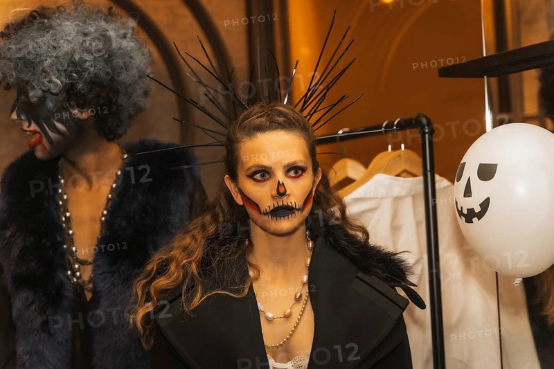 Halloween party with friends in a disco nightclub, portrait of a woman in costume with painted bed