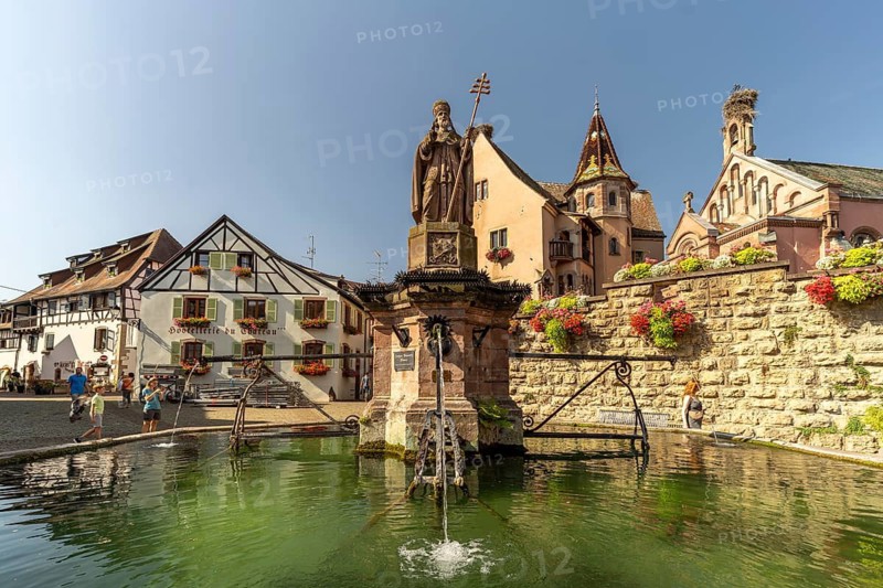 Fountain Fontaine de Saint-Léon and St Leo's Chapel in Eguisheim, Alsace, France