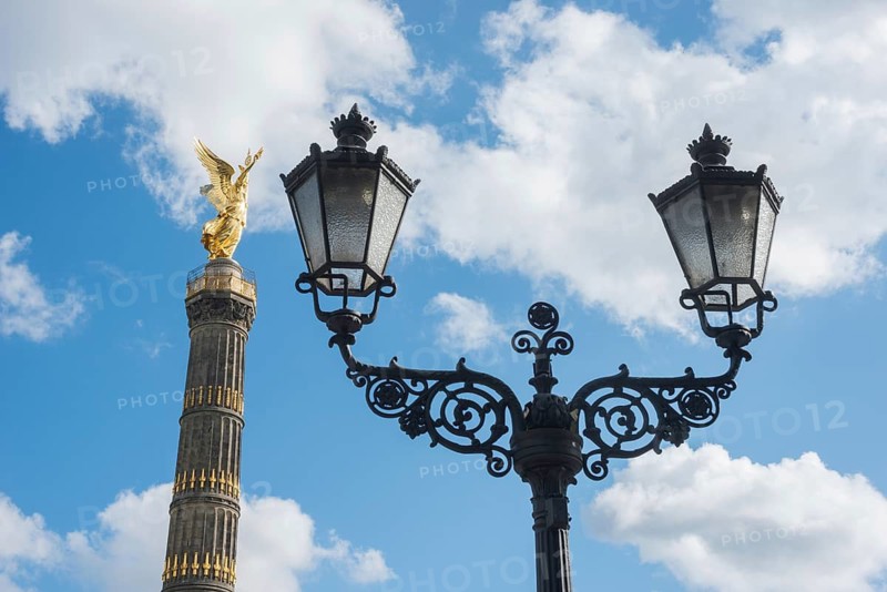 Victory Column next to a beautiful, old street lamp in a blue sky with white clouds, towering column with angel figure, angel, bronze sculpture, bronze, Victory Column on the Great Star with gilded, winged goddess of victory Victoria (artist: Friedrich Drake), in Berlin vernacular also Goldelse, national monument, sight, Großer Tiergarten, Berlin Mitte, City of Berlin, Germany