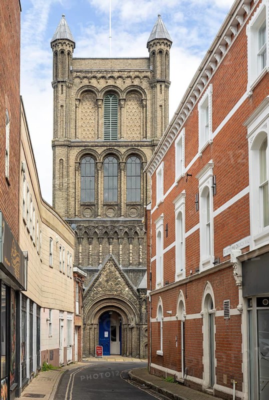 Church tower and entrance doorway at end of narrow St Botolph's Church Walk street, Colchester, Essex, England, UK