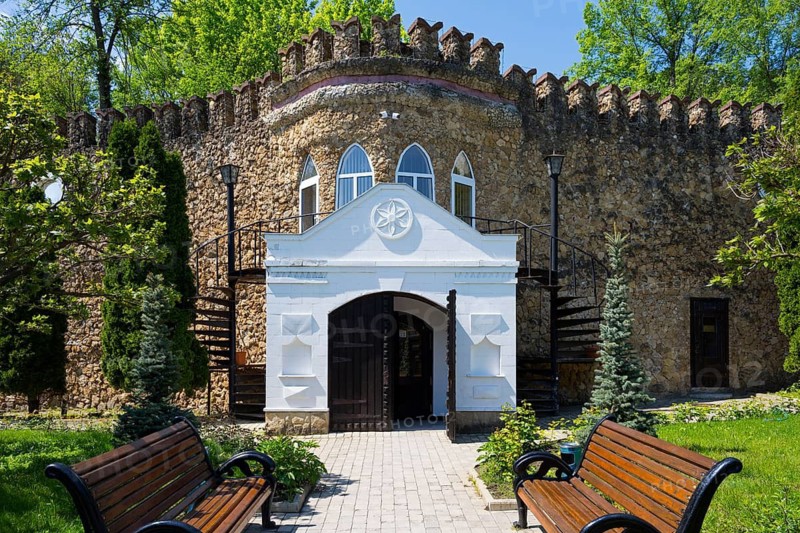 An entrance with decorative stone architecture surrounded by wooden benches and spiral staircases, entrance to the sales room, Milestii Mici Winery, Mile?tii Mici, Republic of Moldova, Moldova