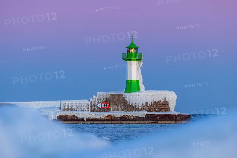 Ice covered Molenfeuer, frozen lighthouse, pier light on mole in Sassnitz harbour at sunset in winter, Rügen Island, Mecklenburg-Vorpommern, Germany