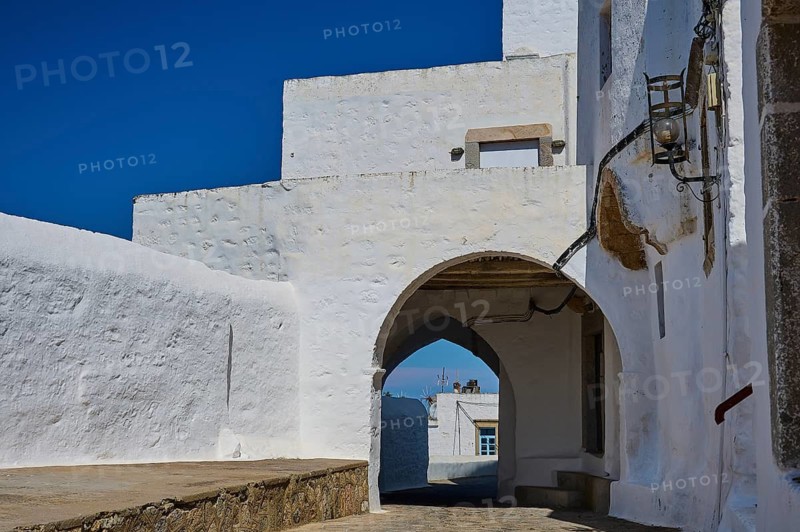 Historic white buildings with arches under a clear blue sky on a sunny day, Chora, main town of Patmos, Patmos, Old Town, Dodecanese, Greek Islands, Greece