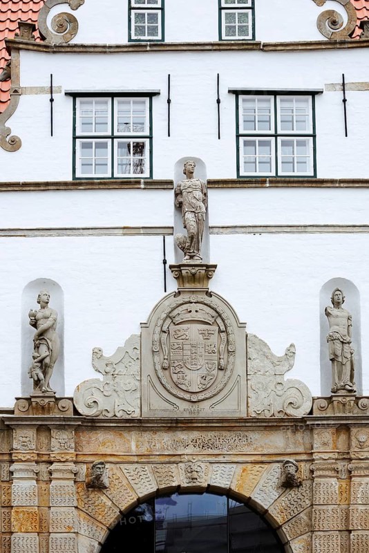 Torhaus am palace gardens, façade with figure and coat of arms, Husum, North Frisia, Schleswig-Holstein, Germany