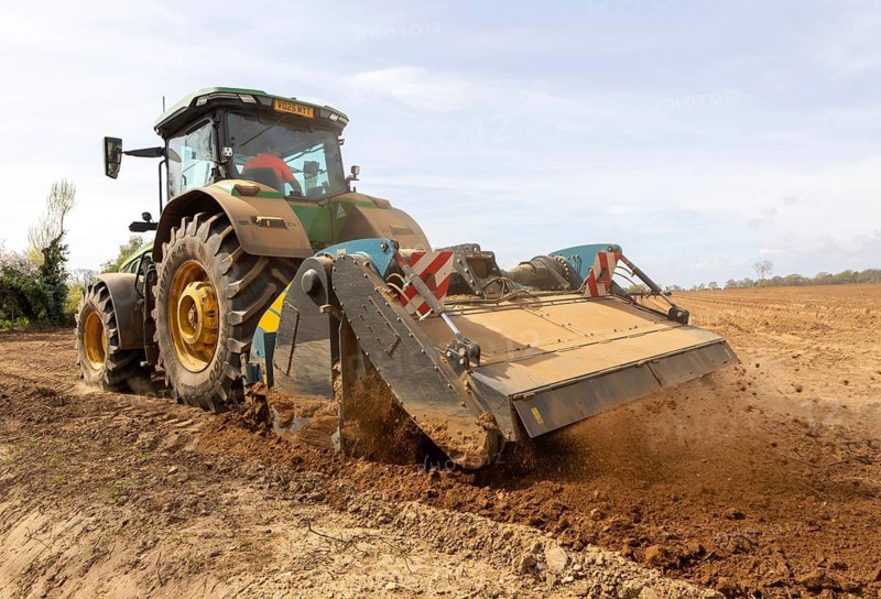 John Deere 8R 340 tractor engaged in field work operating an Agri-World FTC series soil tiller, Shottisham, Suffolk, England, UK