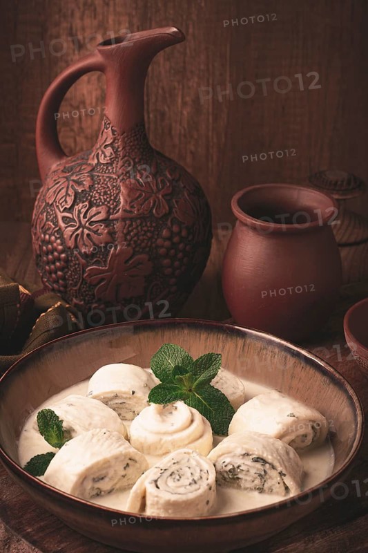 Gebjalia, a traditional Georgian dish, cold appetizer of cheese with mint, Megrelian cuisine, on a wooden table, homemade. no people