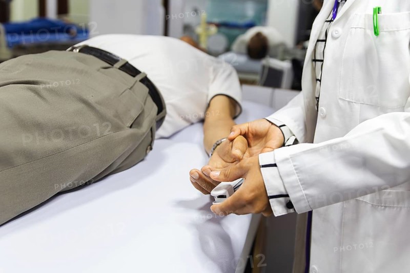 A medical professional checks a patient's oxygen saturation and heart rate using a pulse oximeter in a clinical setting, showcasing essential healthcare practices