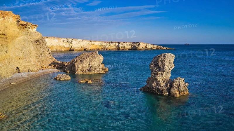 Impressive rock formation in the sea under a clear blue sky and calm water, drone shot, evening light, Araki Beach, southwest coast, Karpathos, Dodecanese, Greek Islands, Greece