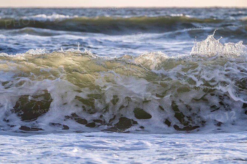 Surf, breaking wave against light, Sortebærdalen Strand, Houvig, North Sea, Denmark