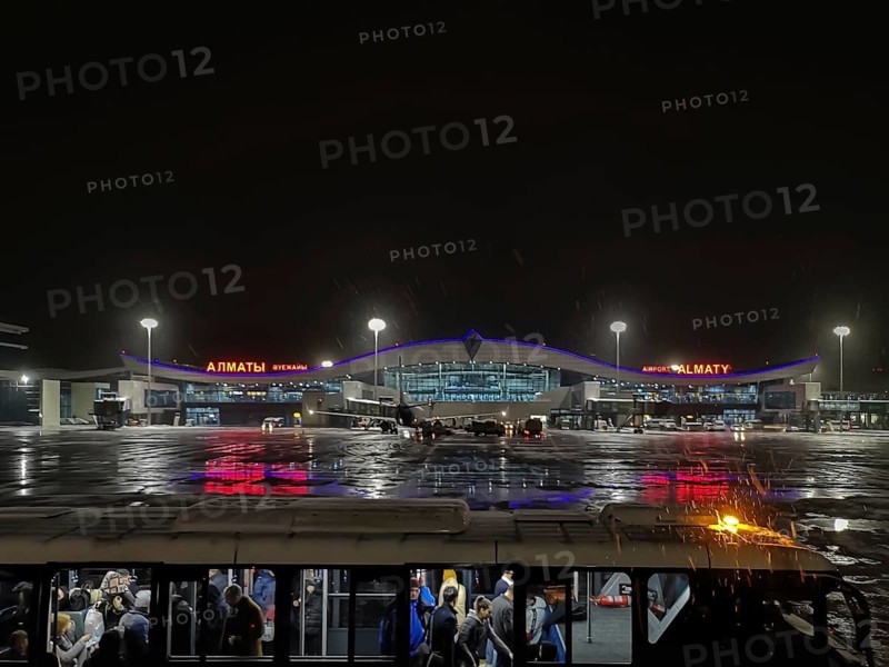 ALMATY, KAZAKHSTAN, NOVEMBER 7, 2019: Night view of Almaty International Airport, Kazakhstan, A view of Almaty airport at night with illuminated signs and a parked bus, Almaty, Kazakhstan