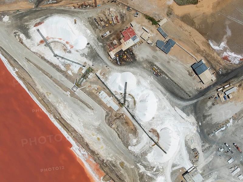 Saline pond and salt heaps at the salt works of Walvis Bay Salt. Aerial view. Drone shot. Walvis Bay, Namibia