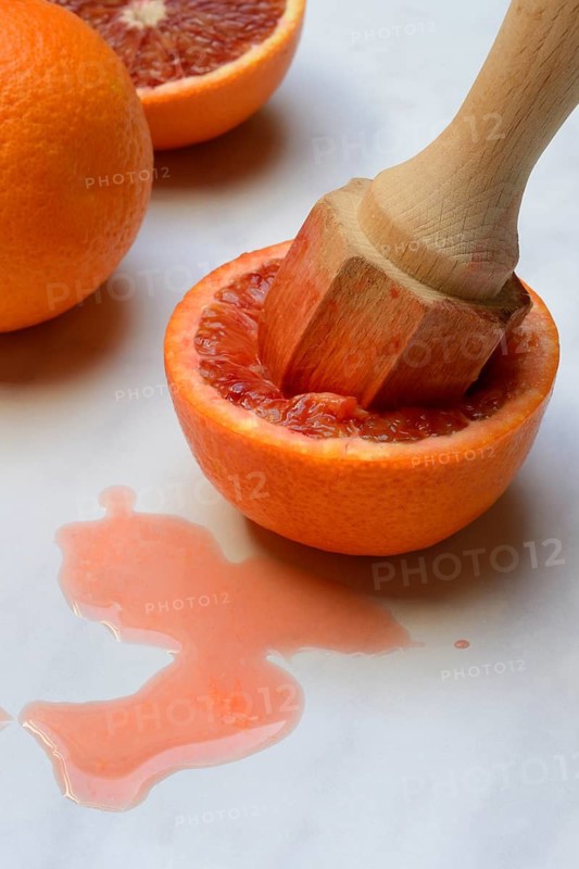 Halved blood orange with citrus squeezer, orange