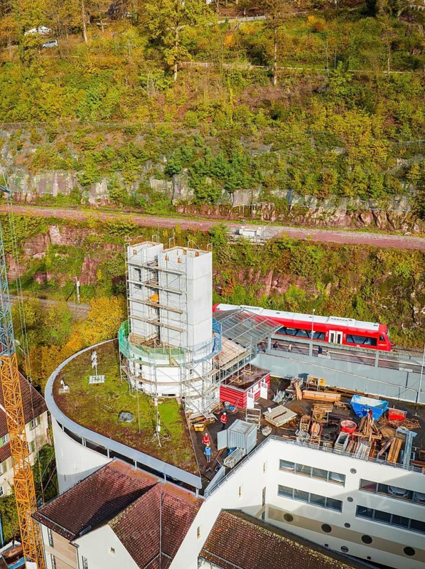 Construction site next to a building with train and rocks in autumnal surroundings, extension of the ZOB Calw for the new track of the Hermann Hessebahn, Calw, Black Forest, Germany