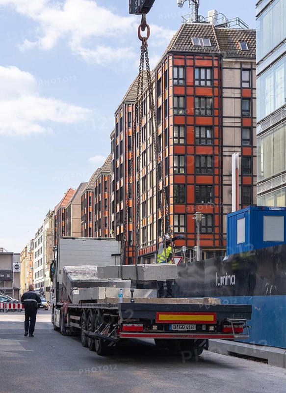 Loading concrete slabs onto a truck trailer using a construction crane, Berlin, Germany