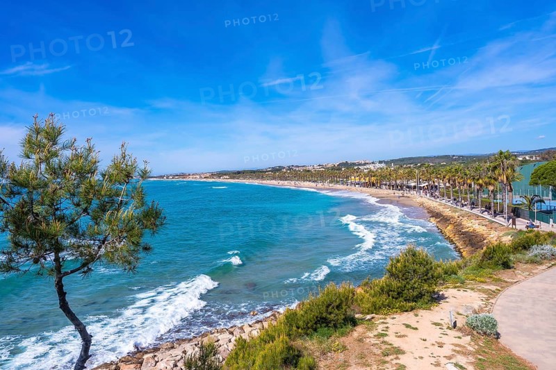 Scenic view of the cami de ronda coastal path stretching along the mediterranean sea towards roc de sant gaieta near comarruga, tarragona, spain, on a beautiful sunny day