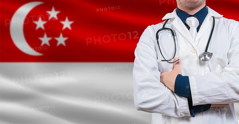 Male doctor with stethoscope on Singapore flag. Doctor holding stethoscope on Singaporean flag
