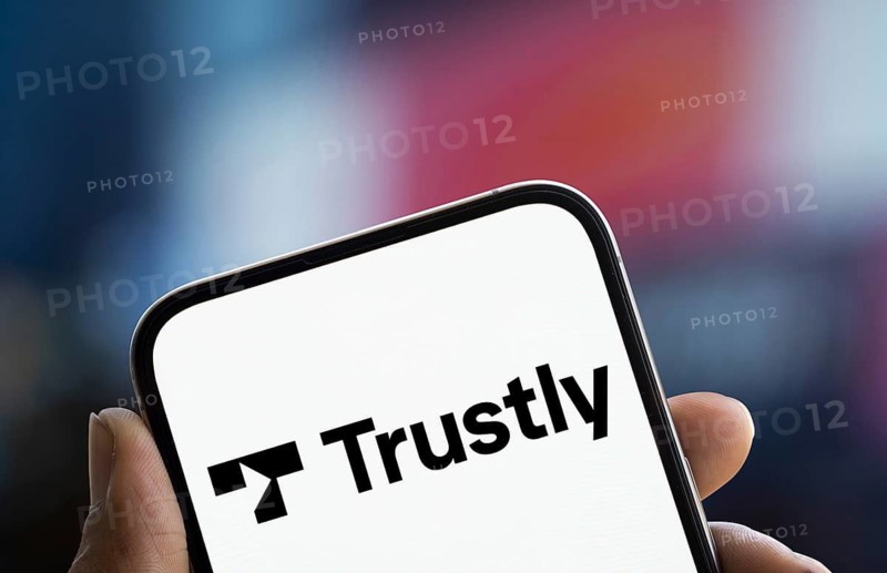 Trustly logo is displayed on smartphone. Trustly AB is a Swedish fintech company
