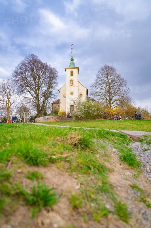 Small church in a meadow, surrounded by bare trees under a cloudy sky. Spring atmosphere, Michelsberg, Bad Münstereifel