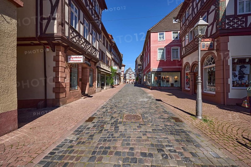 Pedestrian zone with pharmacy museum and lantern under a blue sky, main street in Miltenberg, Lower Franconia, district of Miltenberg, Bavaria, Germany