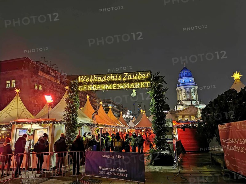 Christmas market on the Gendarmenmarkt at night, festive atmosphere with many visitors, Berlin