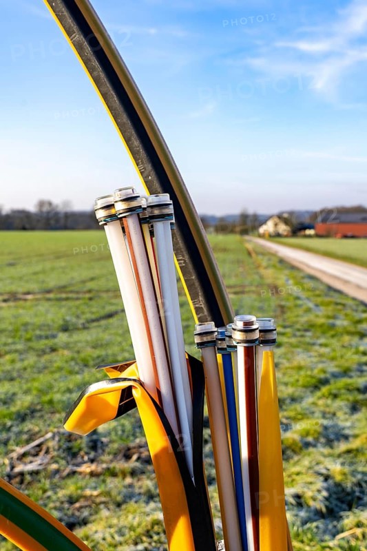 Fibre optic connection, empty conduits protrude from the ground along a dirt track, into which the actual fibre optic cable is later blown and connected to the respective house connection or distributor, provision of fast Internet in rural areas, in the south of Mülheim an der Ruhr, North Rhine-Westphalia, Germany