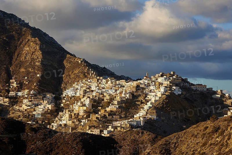 A traditional village lies on a mountain, illuminated by the low sun, Colourful mountain village, Morning light, Olymbos, Karpathos, Dodecanese, Greek Islands, Greece